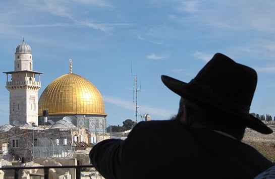 An Orthodox Jewish man looks at the Dome of the Rock